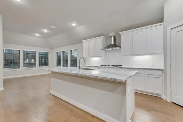 a kitchen with granite countertop a sink and white cabinets