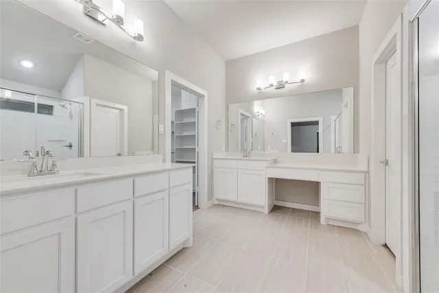 a bathroom with double vanity and a mirror