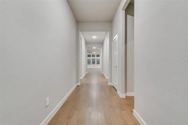 a view of a hallway with wooden floor