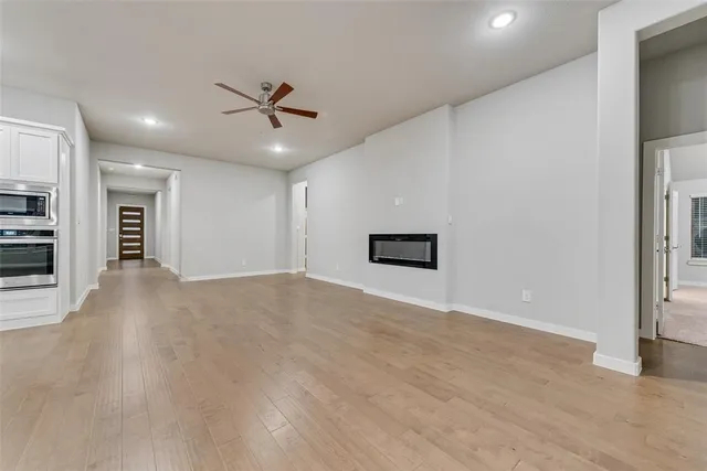 an empty room with windows and ceiling fan