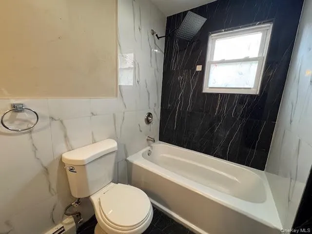 a white toilet sitting next to a bathroom sink and tub