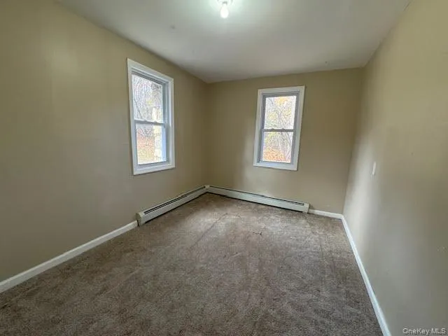a view of an empty room with wooden floor and a ceiling fan