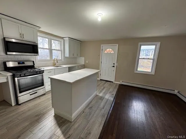 a kitchen with a sink stove and wooden floor