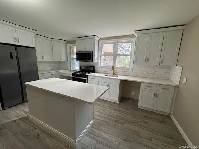 a kitchen with a sink a window a refrigerator and a stove top oven