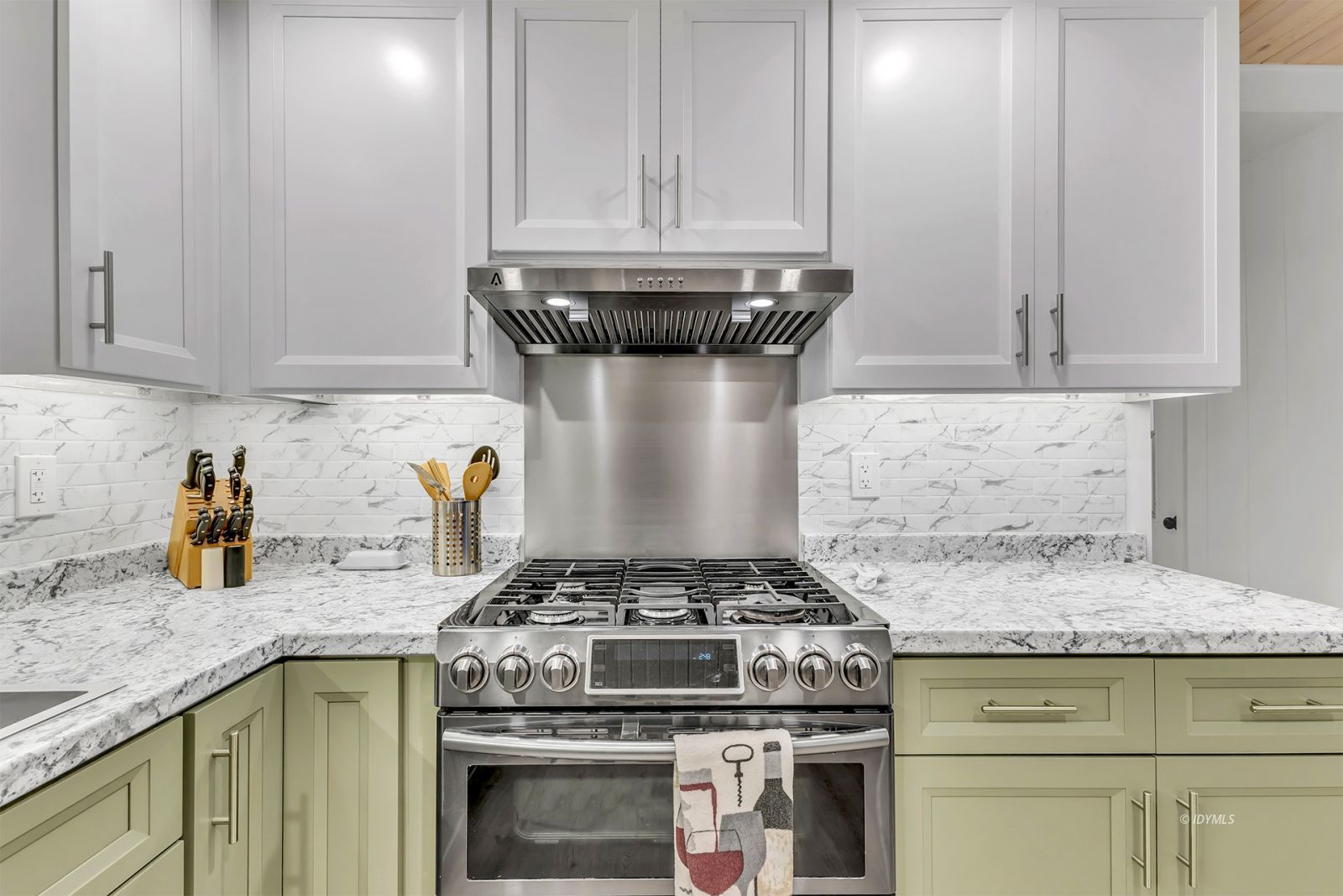 52901 Pine Cove Road, Unit 43 Idyllwild-Pine Cove, CA 92549 - Photo 18 of 37 a kitchen with granite countertop a stove and white cabinets