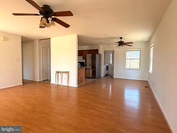 a view of a kitchen with a sink refrigerator and wooden floor