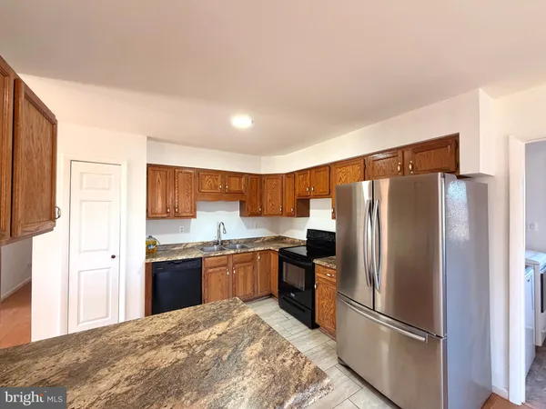 a large kitchen with stainless steel appliances granite countertop a refrigerator sink and stove