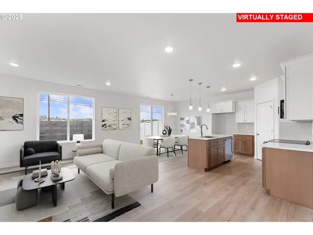 a living room with furniture kitchen view and a large window