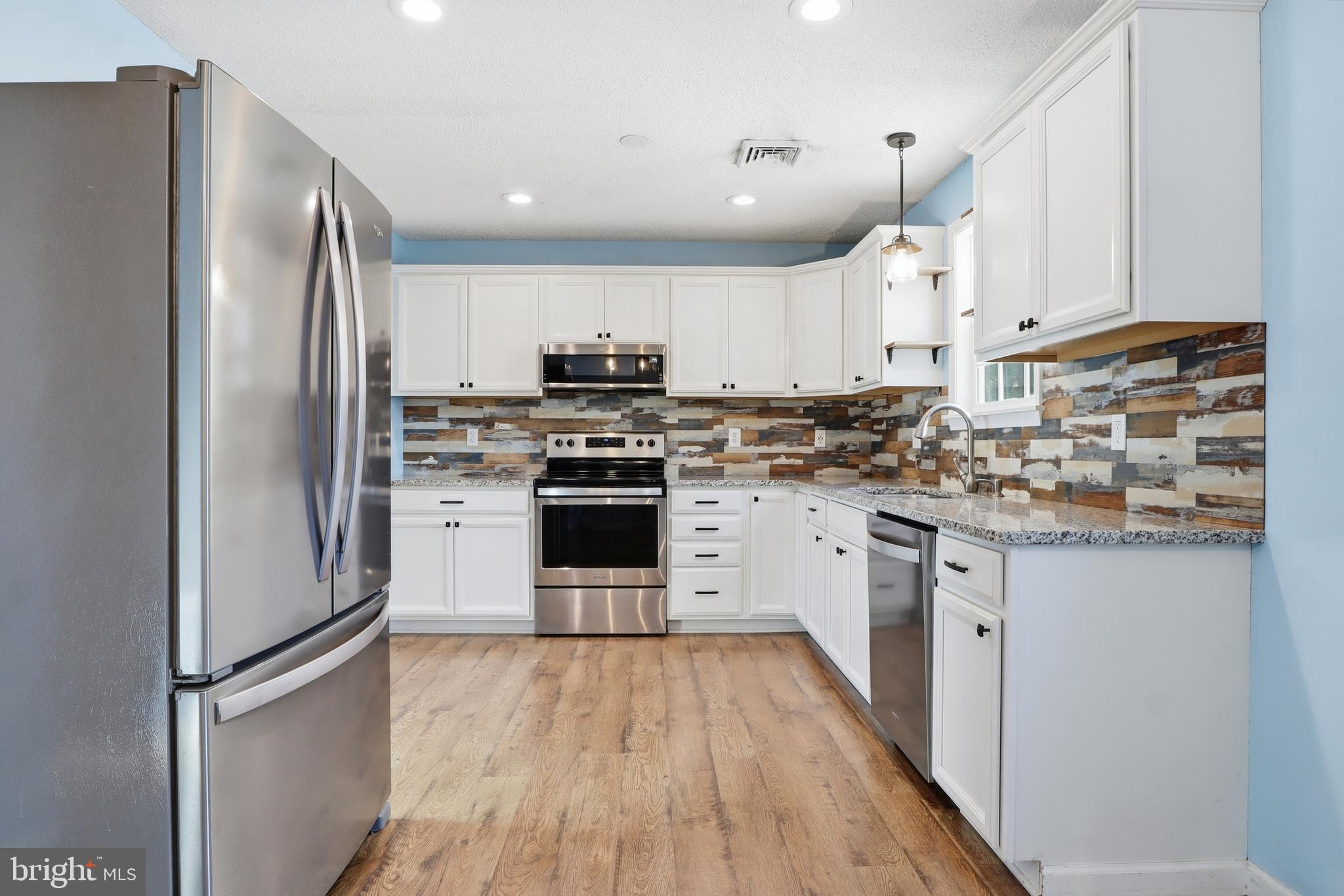 276 Oakbrook Drive Felton, PA 17322 - Photo 6 of 55 a kitchen with cabinets stainless steel appliances and wooden floor