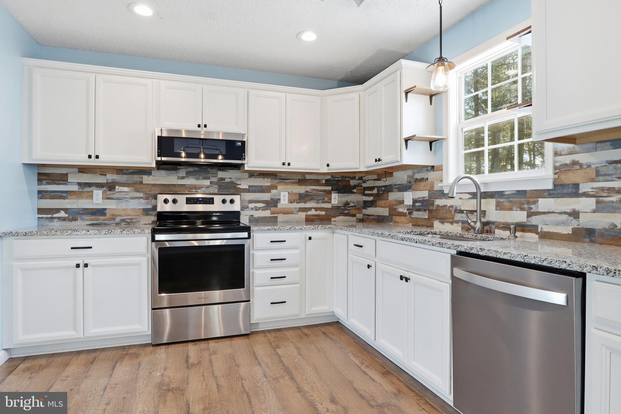276 Oakbrook Drive Felton, PA 17322 - Photo 7 of 55 a kitchen with stainless steel appliances granite countertop a stove a sink and a microwave