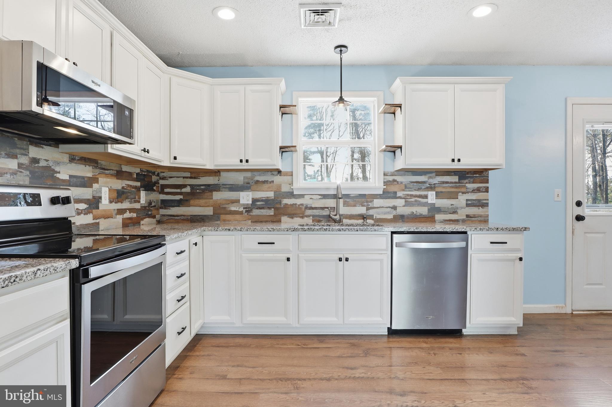 276 Oakbrook Drive Felton, PA 17322 - Photo 8 of 55 a kitchen with stainless steel appliances granite countertop a stove a sink and white cabinets