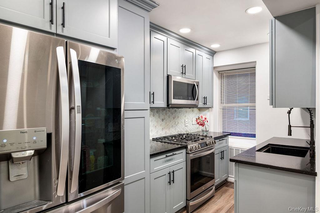 70 Locust Avenue, Unit B101 New Rochelle, NY 10801 - Photo 7 of 11 a kitchen with stainless steel appliances a refrigerator sink and stove