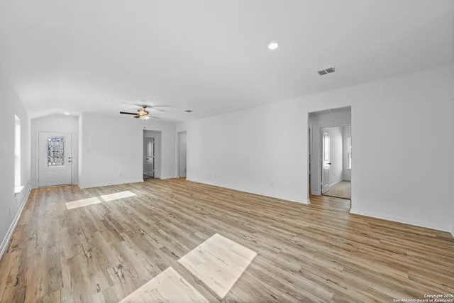 a view of empty room with wooden floor