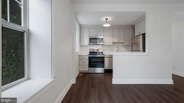 a kitchen with a refrigerator and a stove top oven
