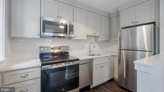 a kitchen with cabinets stainless steel appliances and a sink