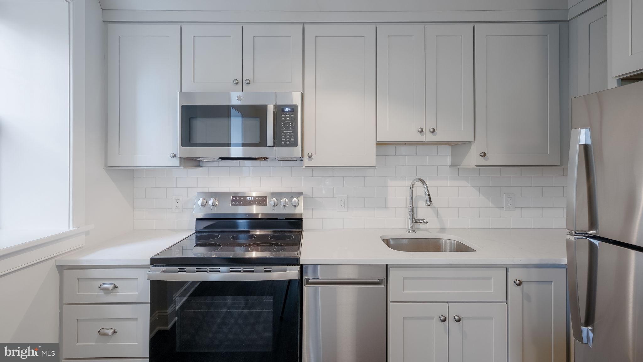 115 Harvey Avenue, Unit 1171 Doylestown, PA 18901 - Photo 13 of 26 a kitchen with stainless steel appliances granite countertop a stove a microwave and cabinets