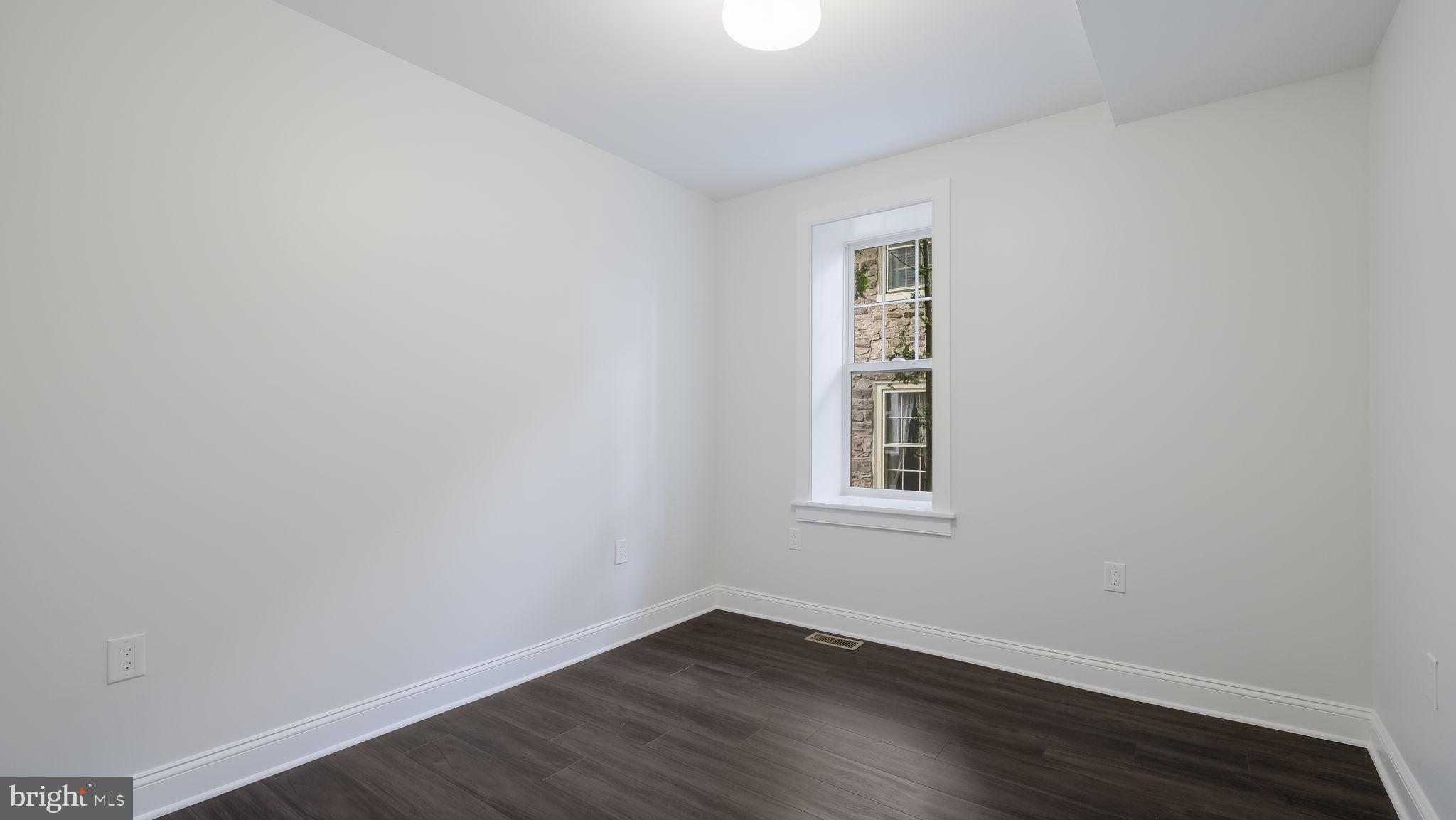 115 Harvey Avenue, Unit 1171 Doylestown, PA 18901 - Photo 14 of 26 an empty room with wooden floor and windows