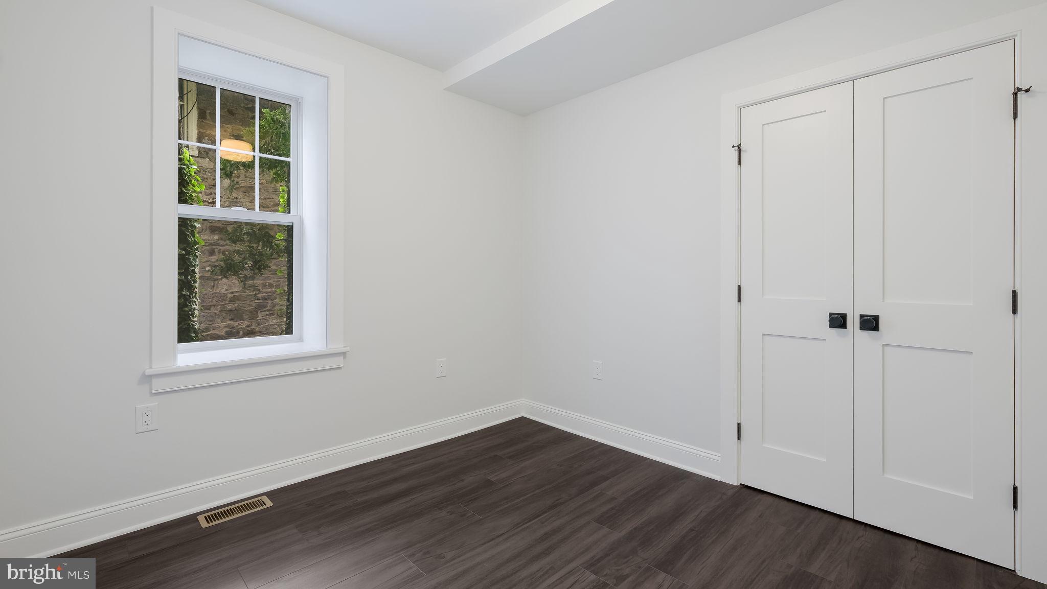 115 Harvey Avenue, Unit 1171 Doylestown, PA 18901 - Photo 15 of 26 a view of an empty room with wooden floor and a window