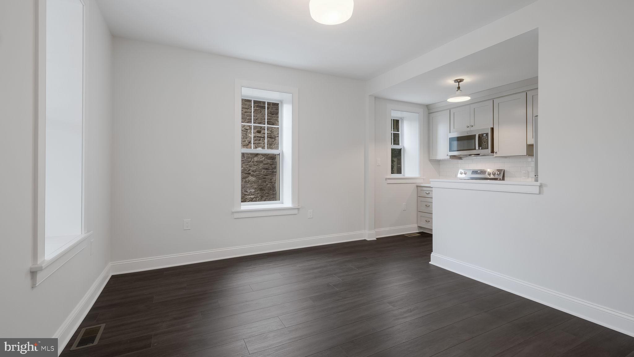 115 Harvey Avenue, Unit 1171 Doylestown, PA 18901 - Photo 7 of 26 an empty room with wooden floor and windows