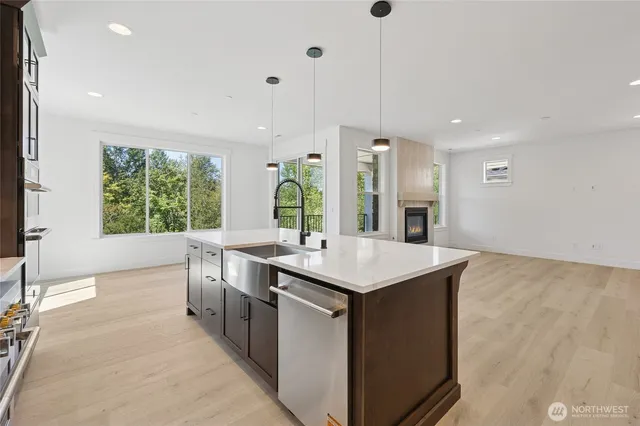 a kitchen with kitchen island a sink stove and a large window