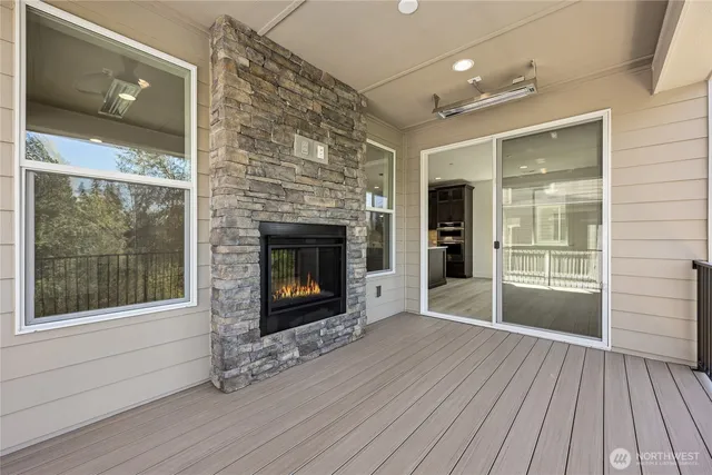 an empty room with wooden floor a fireplace and windows