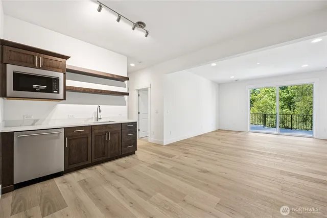 a view of a kitchen with a sink dishwasher and fireplace