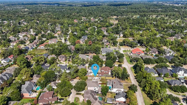 an aerial view of residential houses with outdoor space and trees