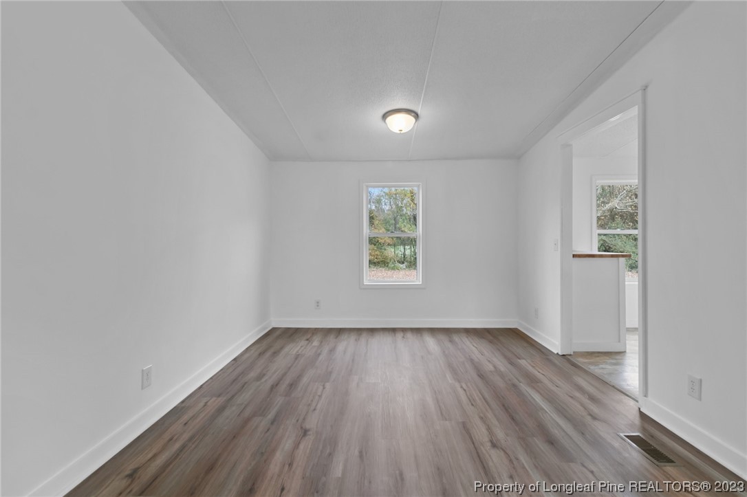420 Ridge Lane Autryville, NC 28318 - Photo 14 of 39 an empty room with wooden floor and windows