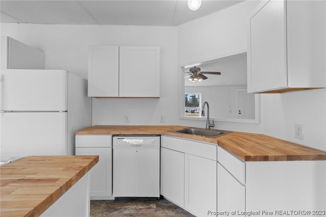 420 Ridge Lane Autryville, NC 28318 - Photo 17 of 39 a kitchen with a sink dishwasher and white cabinets