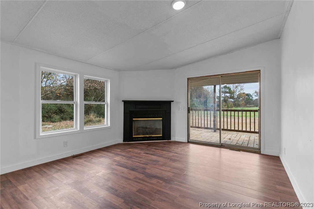 420 Ridge Lane Autryville, NC 28318 - Photo 19 of 39 an empty room with wooden floor and fireplace