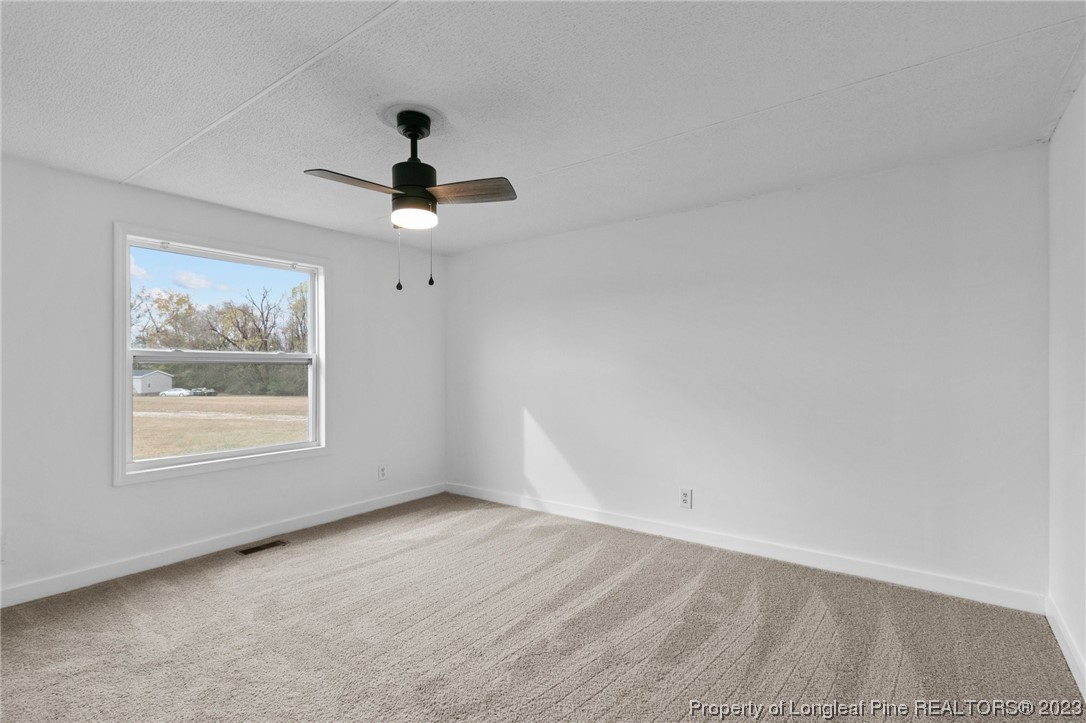 420 Ridge Lane Autryville, NC 28318 - Photo 24 of 39 an empty room with a window and a ceiling fan