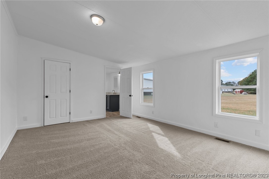 420 Ridge Lane Autryville, NC 28318 - Photo 10 of 39 an empty room with windows and closet
