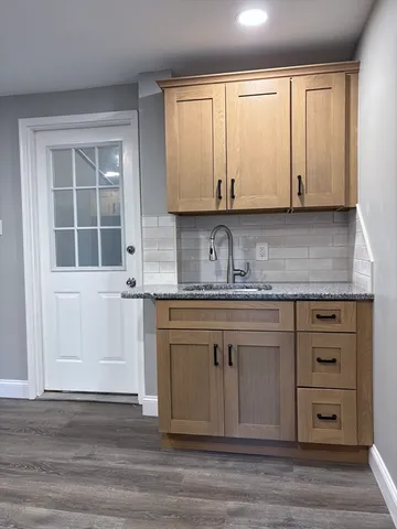 a kitchen with granite countertop white cabinets and sink