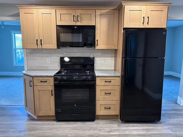 a kitchen with stainless steel appliances granite countertop a refrigerator and a stove top oven