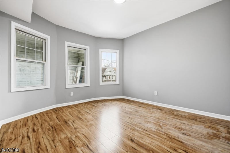 76 Riggs Place, Unit 2 West Orange, NJ 07052 - Photo 12 of 24 a view of an empty room with wooden floor and a window