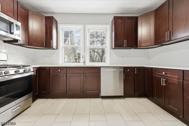 a kitchen with stainless steel appliances granite countertop a stove and a microwave