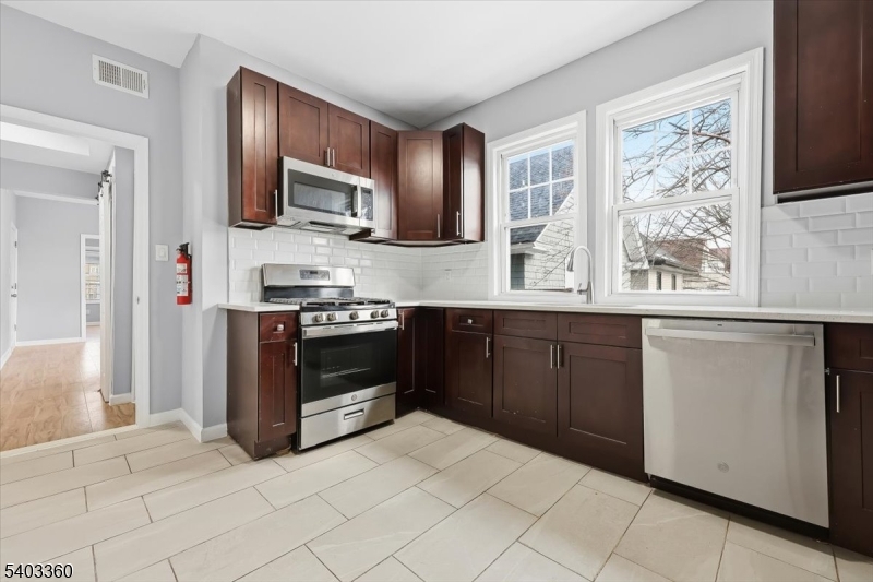 76 Riggs Place, Unit 2 West Orange, NJ 07052 - Photo 4 of 24 a kitchen with stainless steel appliances a stove sink and microwave