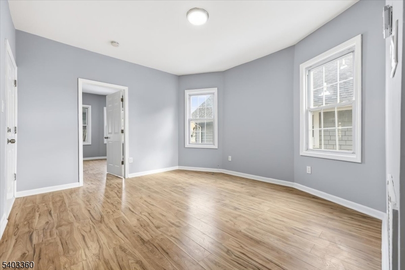 76 Riggs Place, Unit 2 West Orange, NJ 07052 - Photo 7 of 24 a view of an empty room with wooden floor and a window