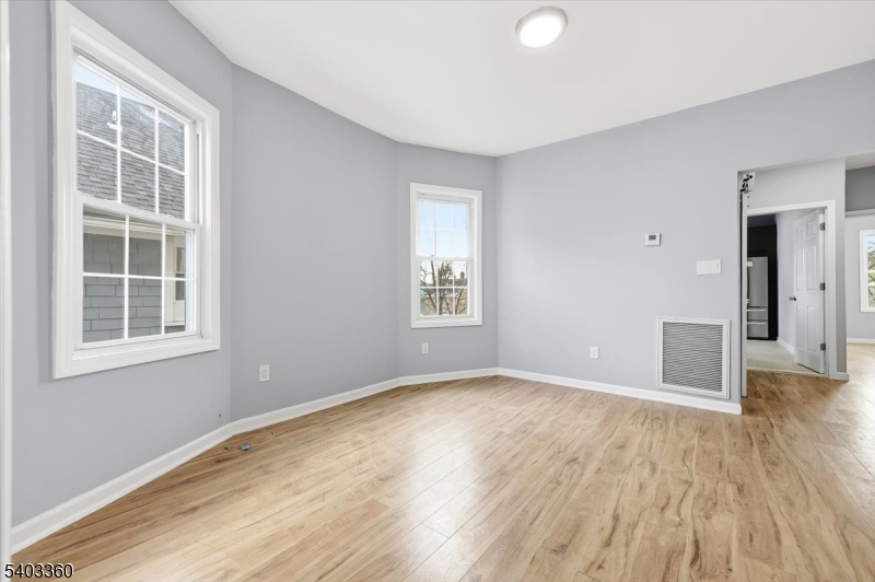 76 Riggs Place, Unit 2 West Orange, NJ 07052 - Photo 9 of 24 a view of an empty room with wooden floor and a window