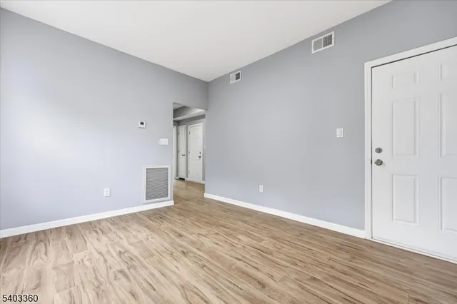 a view of an empty room with wooden floor