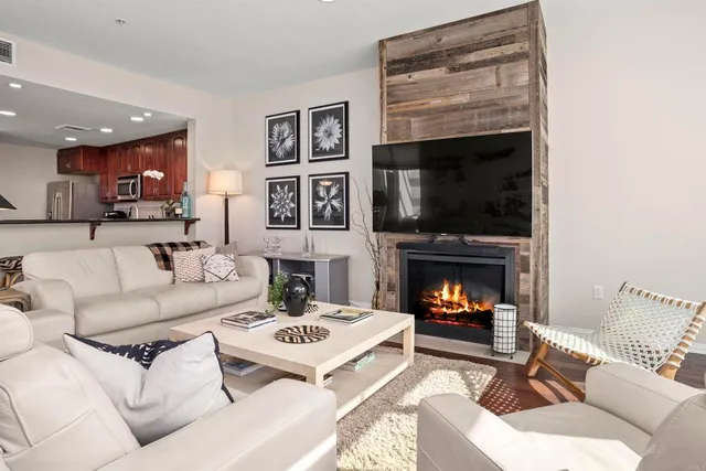 a living room with furniture a fireplace and a flat screen tv