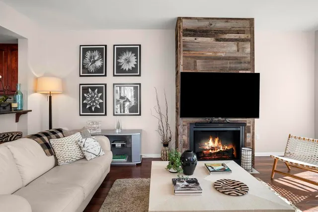 a living room with furniture a flat screen tv and a fireplace