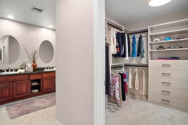 a view of walk in closet with clothes and shoes