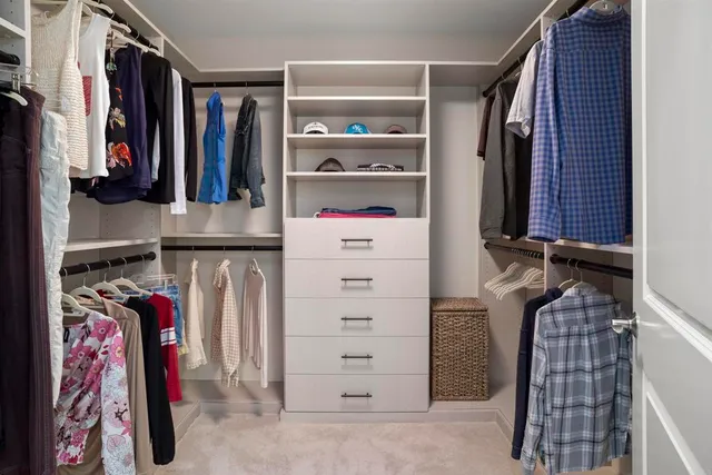 a view of walk in closet with clothes