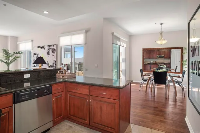 a kitchen with stainless steel appliances granite countertop wooden floors and white cabinets