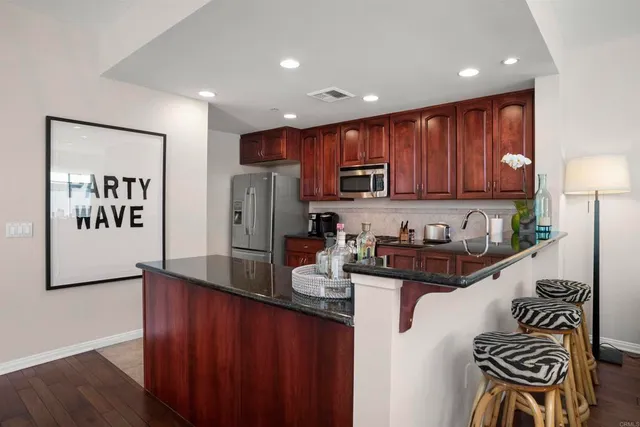 a kitchen with granite countertop wooden cabinets a stove top oven a sink and dishwasher