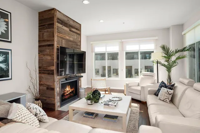 a living room with furniture a fireplace and a large window