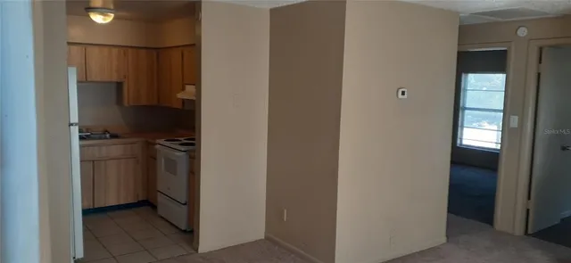 a kitchen with a refrigerator and white cabinets