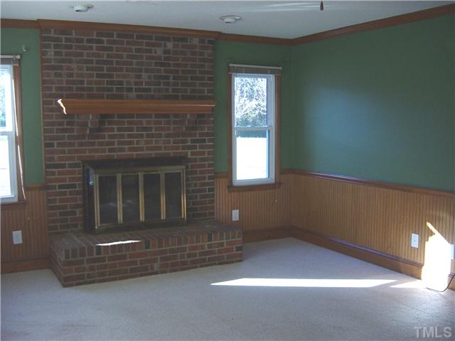 Huge family room with cozy fireplace, crown molding and beaded board.