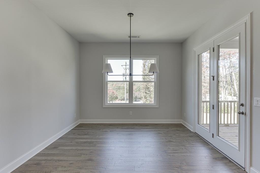 446 Thunder Road Buford, GA 30518 - Photo 15 of 79 a view of an empty room with wooden floor and windows
